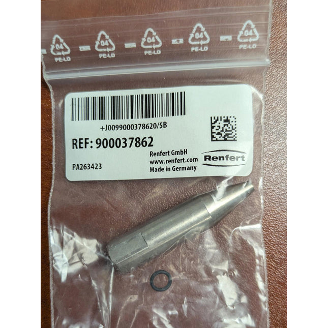 Small metal component in a clear plastic bag with Renfert branding on a wooden surface